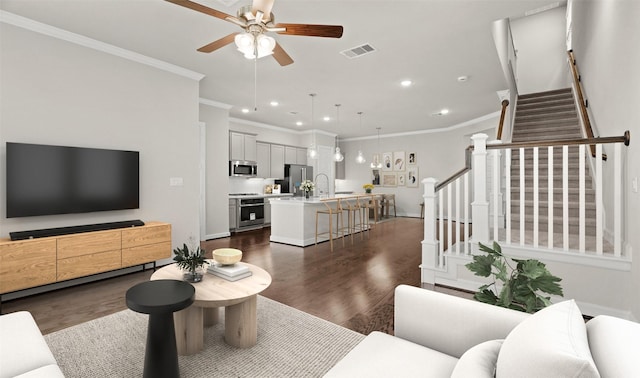 living room featuring crown molding, recessed lighting, a ceiling fan, dark wood-style flooring, and stairway