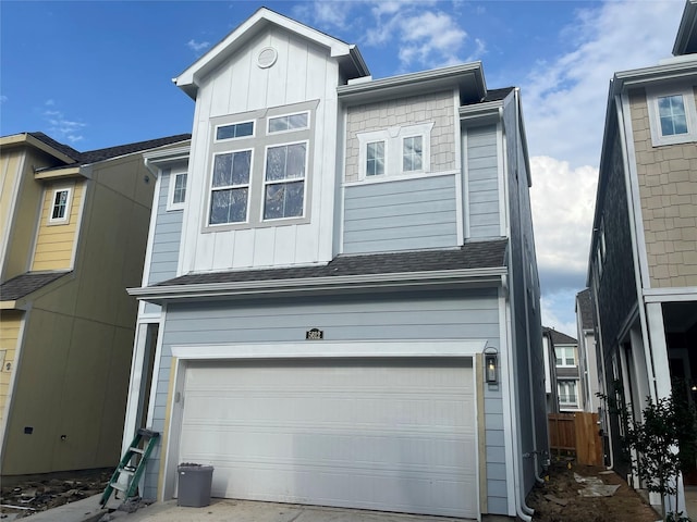 view of front facade with a garage, driveway, board and batten siding, and a shingled roof