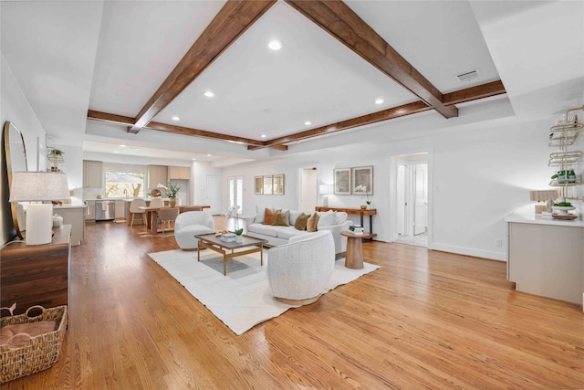 living area featuring beamed ceiling, recessed lighting, light wood-style floors, and visible vents