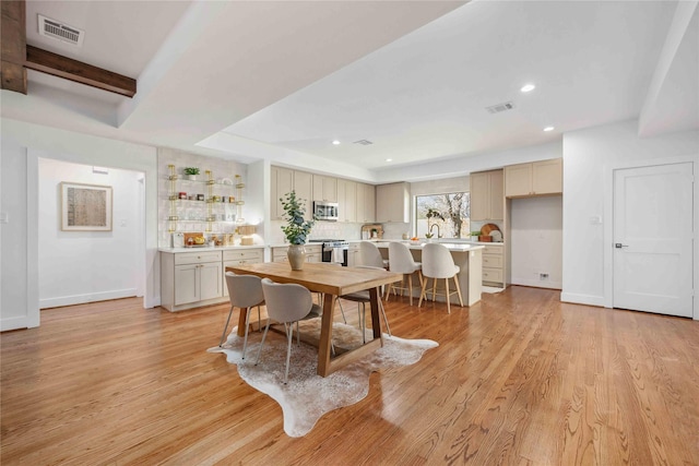 dining space with visible vents, baseboards, and light wood-style floors