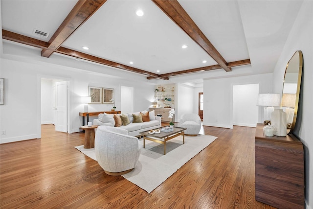 living area featuring beamed ceiling, wood finished floors, and baseboards