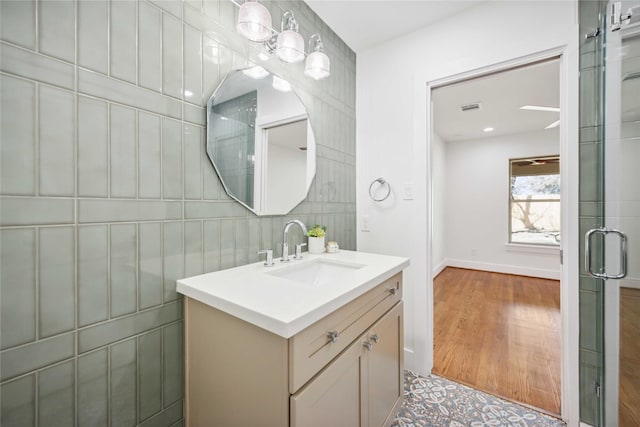 bathroom featuring visible vents, vanity, baseboards, and wood finished floors