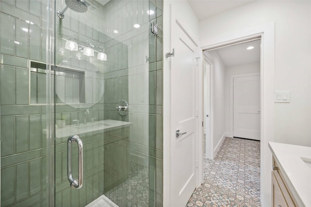 bathroom featuring baseboards, vanity, and a shower stall