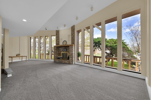 unfurnished living room featuring recessed lighting, a healthy amount of sunlight, a fireplace, and carpet floors