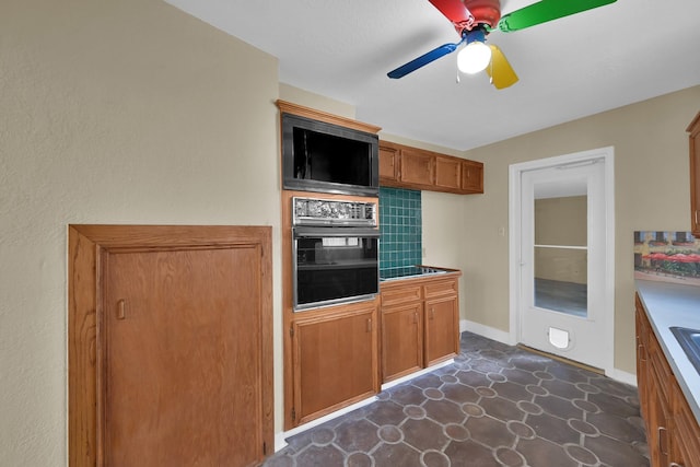 kitchen featuring black appliances, baseboards, brown cabinets, and ceiling fan