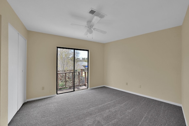 unfurnished room featuring baseboards, visible vents, dark colored carpet, and ceiling fan