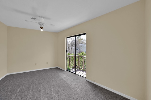 empty room featuring visible vents, dark carpet, baseboards, and a ceiling fan