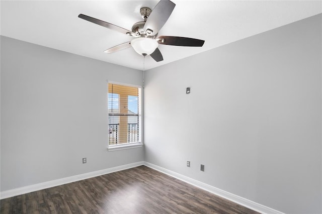 spare room featuring baseboards, ceiling fan, and dark wood-style flooring