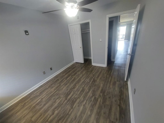 unfurnished bedroom featuring visible vents, dark wood-style floors, a closet, baseboards, and ceiling fan