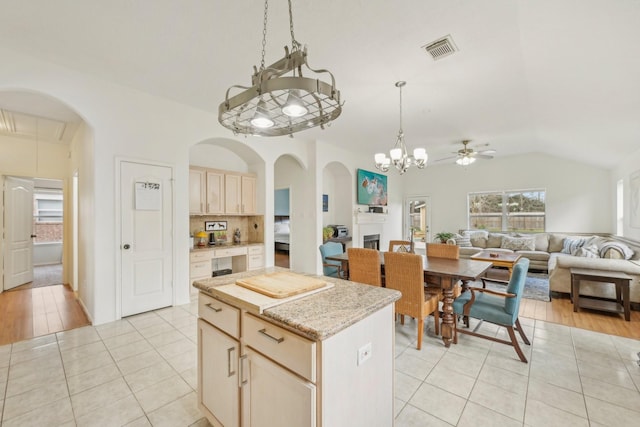 kitchen featuring visible vents, a kitchen island, open floor plan, light tile patterned flooring, and hanging light fixtures