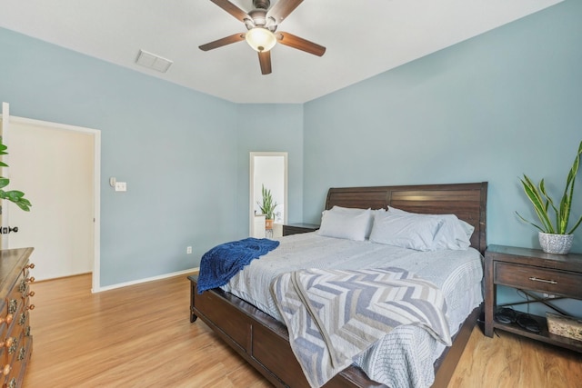 bedroom with a ceiling fan, wood finished floors, and baseboards