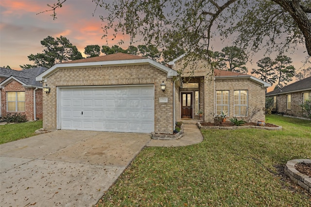 single story home featuring a yard, brick siding, concrete driveway, and an attached garage