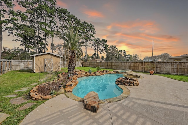 view of swimming pool featuring a storage unit, an outbuilding, a patio, a fenced backyard, and a yard