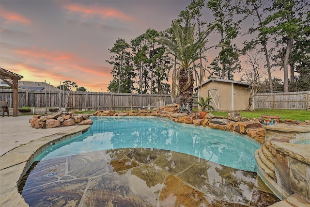 view of pool with a fenced in pool, a yard, a fenced backyard, an outdoor structure, and a storage shed