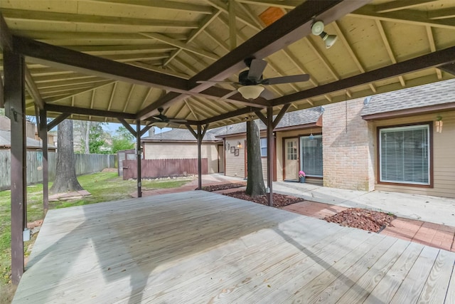 wooden deck featuring a lawn, a ceiling fan, and fence