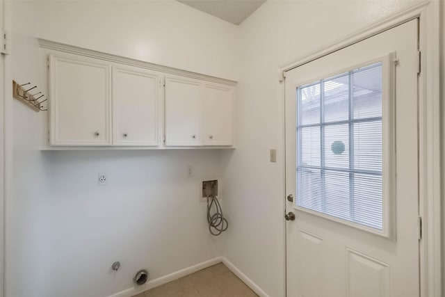 laundry room featuring electric dryer hookup, cabinet space, light tile patterned floors, baseboards, and hookup for a washing machine