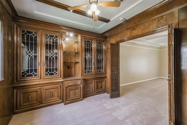 interior space with a ceiling fan, carpet, crown molding, and a textured ceiling