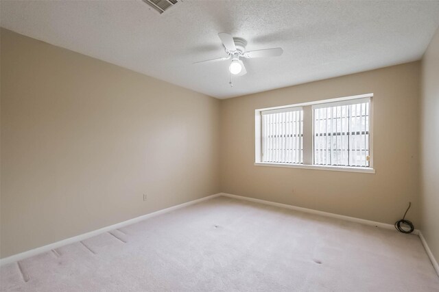 unfurnished room featuring baseboards, visible vents, ceiling fan, a textured ceiling, and light colored carpet