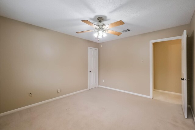 unfurnished room with visible vents, light colored carpet, and baseboards