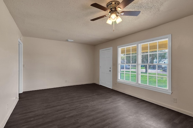 unfurnished room with ceiling fan, a textured ceiling, dark wood-type flooring, and baseboards