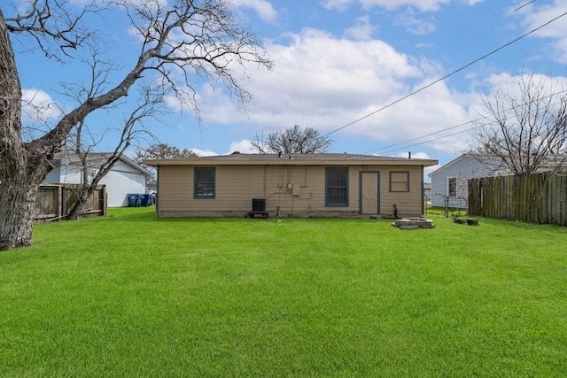 rear view of property featuring crawl space, a lawn, central AC unit, and a fenced backyard