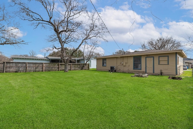 back of property with cooling unit, a lawn, and fence