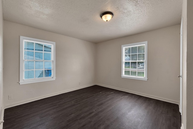 unfurnished room featuring dark wood finished floors, baseboards, and a textured ceiling