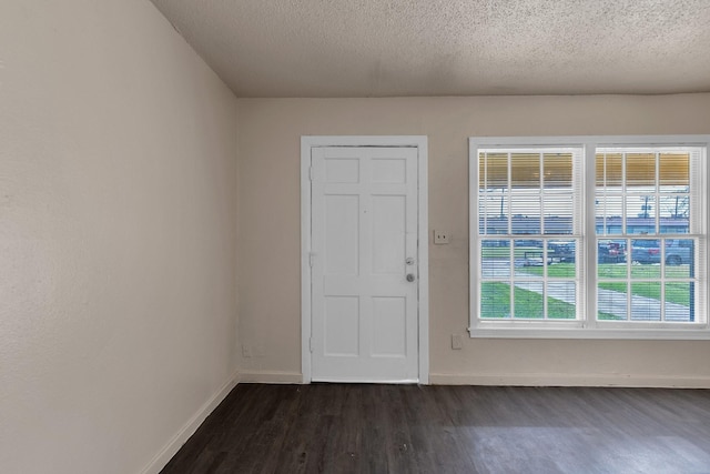 entrance foyer with dark wood finished floors, baseboards, and a textured ceiling