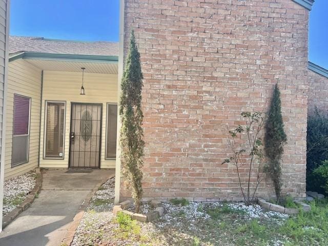 entrance to property featuring brick siding