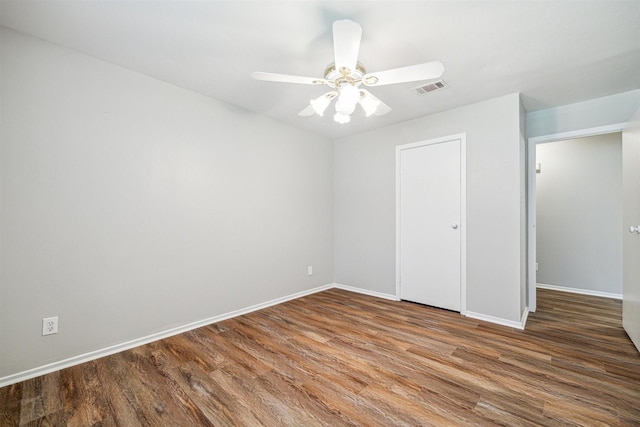 unfurnished bedroom with ceiling fan, wood finished floors, visible vents, and baseboards