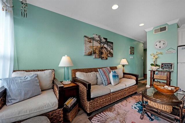 living room featuring visible vents, recessed lighting, crown molding, and wood finished floors