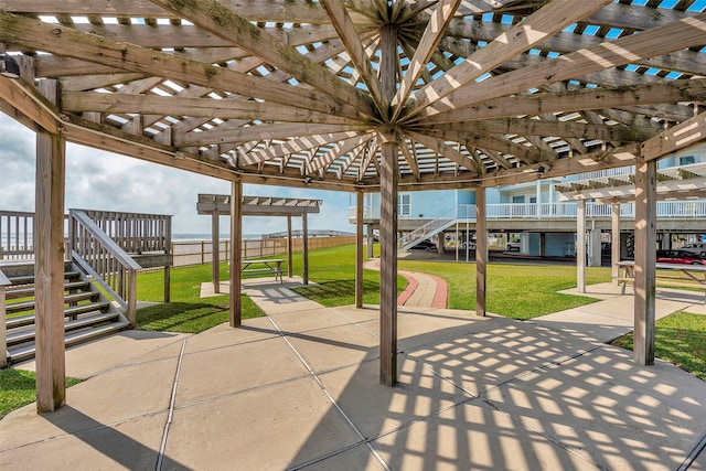 view of patio with stairs, fence, and a pergola