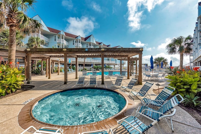 community pool with a patio area, a hot tub, and a pergola