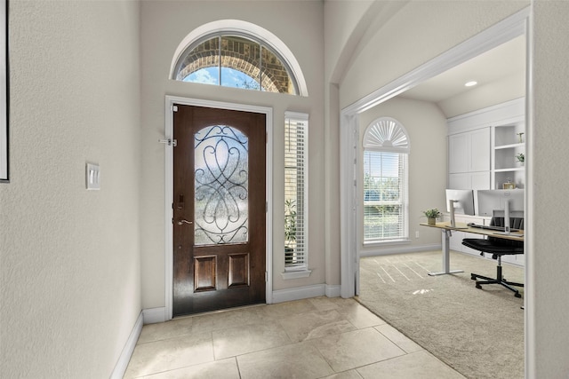 entrance foyer featuring light colored carpet and baseboards