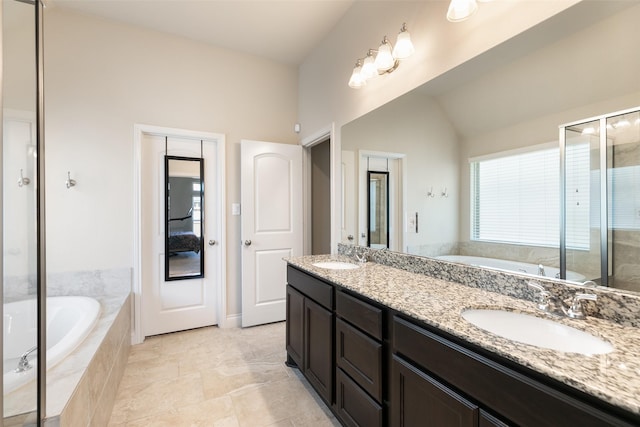 full bathroom featuring a bath, double vanity, lofted ceiling, and a sink