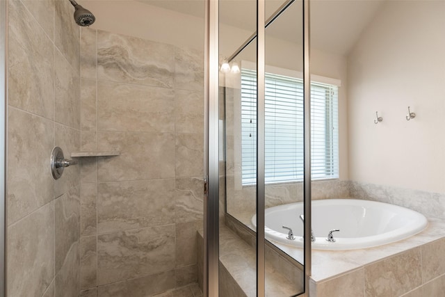 bathroom featuring lofted ceiling, a bath, and a stall shower