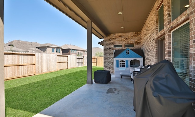 view of patio / terrace featuring a grill, a fenced backyard, and a fireplace