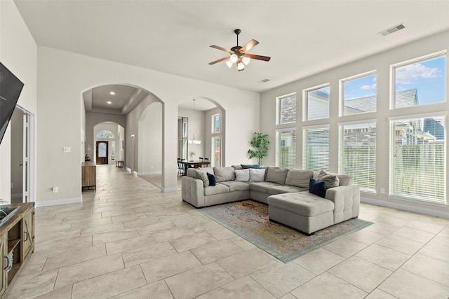 living room featuring a wealth of natural light, visible vents, and a towering ceiling