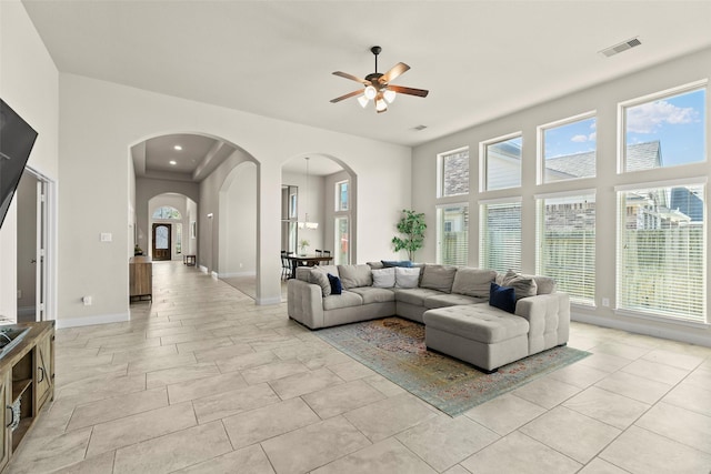 10015 Starhill Ct, Missouri City, TX 77459 - living room featuring arched walkways, plenty of natural light, a ceiling fan, a high ceiling, and recessed lighting