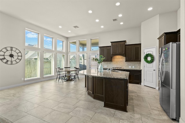 10015 Starhill Ct, Missouri City, TX 77459 - kitchen with freestanding refrigerator, a sink, recessed lighting, decorative backsplash, and light stone countertops