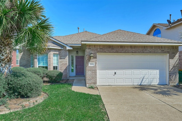 single story home with driveway, roof with shingles, a front lawn, a garage, and brick siding