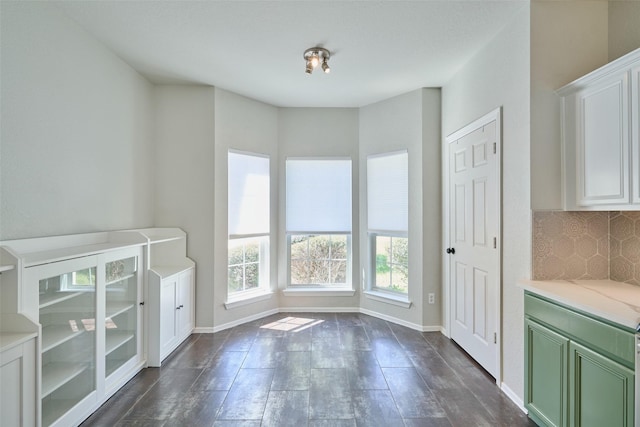 interior space featuring baseboards and dark wood-style flooring