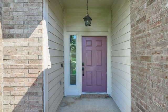 view of exterior entry with brick siding