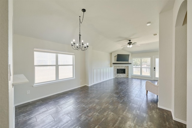 unfurnished living room featuring visible vents, baseboards, lofted ceiling, a fireplace, and ceiling fan with notable chandelier