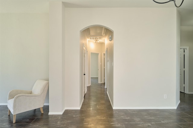 hallway with baseboards, arched walkways, and visible vents