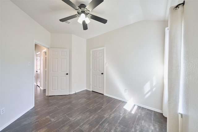 unfurnished bedroom featuring vaulted ceiling, ceiling fan, baseboards, and dark wood-style flooring