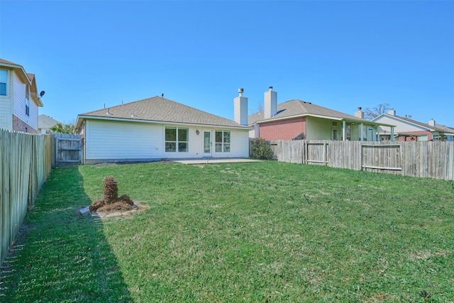 back of house featuring a patio, a lawn, and a fenced backyard