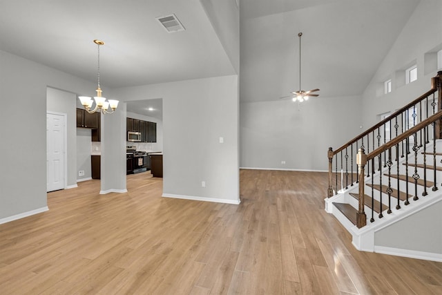 unfurnished living room with visible vents, baseboards, stairway, ceiling fan with notable chandelier, and light wood-style floors