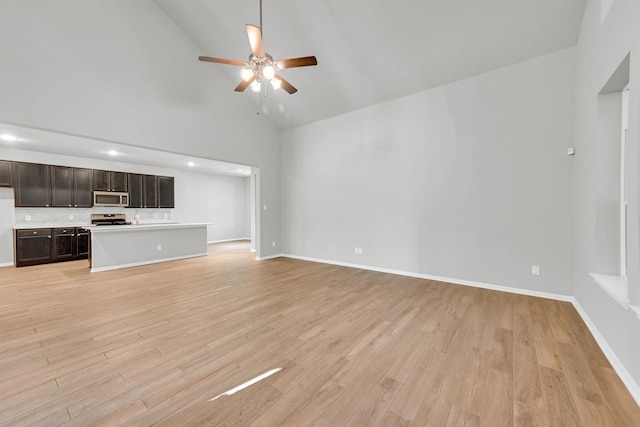 unfurnished living room with light wood finished floors, baseboards, high vaulted ceiling, and a ceiling fan