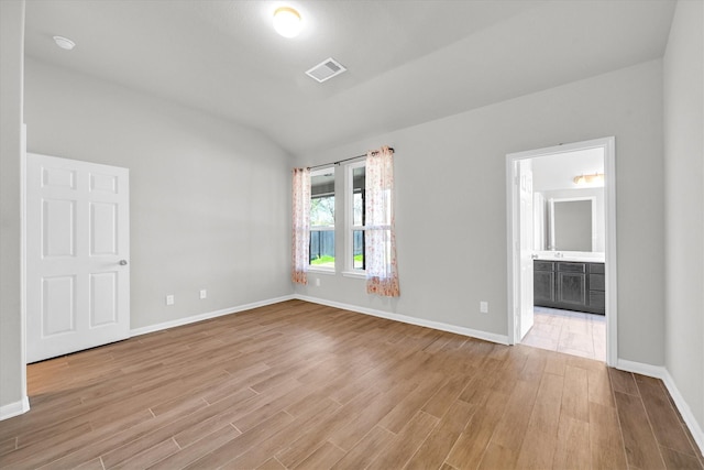 empty room featuring baseboards, visible vents, and light wood finished floors